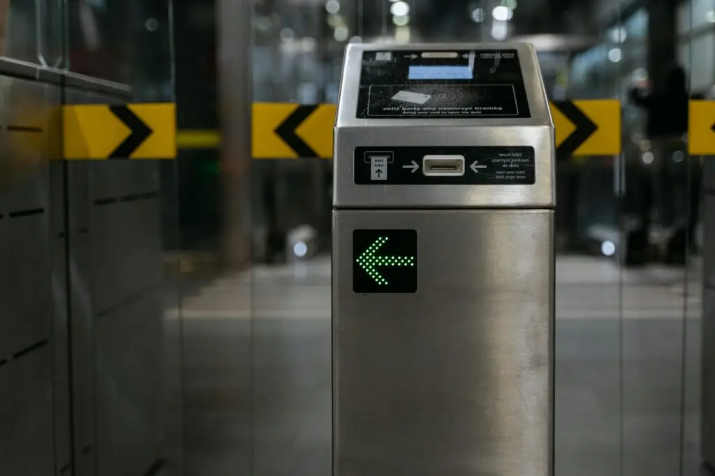 A modern ticket gate with an illuminated arrow for access control in transit systems.
